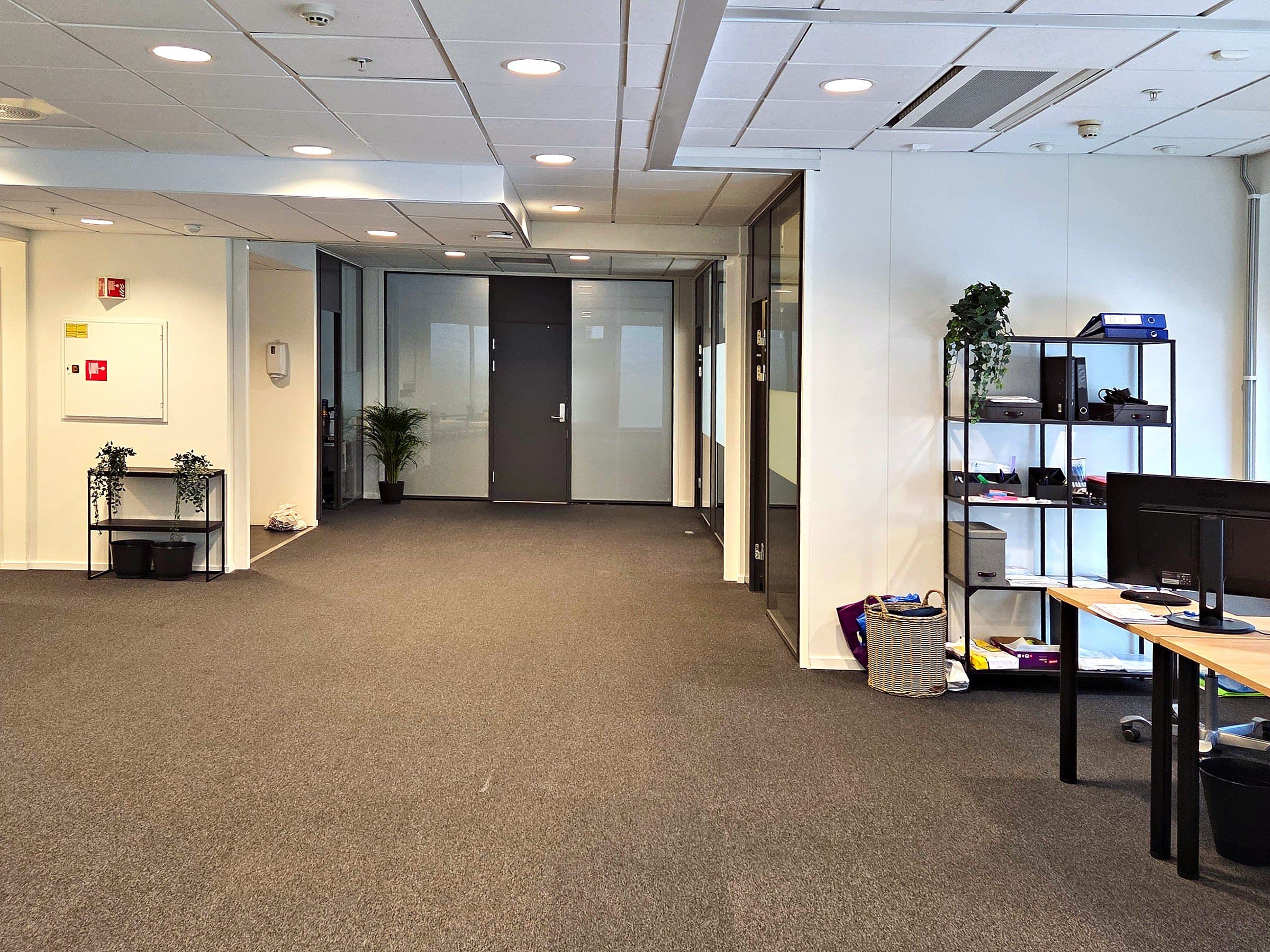 Kontorlandskapet med gang, hyller og arbeidsplasser